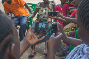 Women sitting in a circle taking a selfie on a smart phone